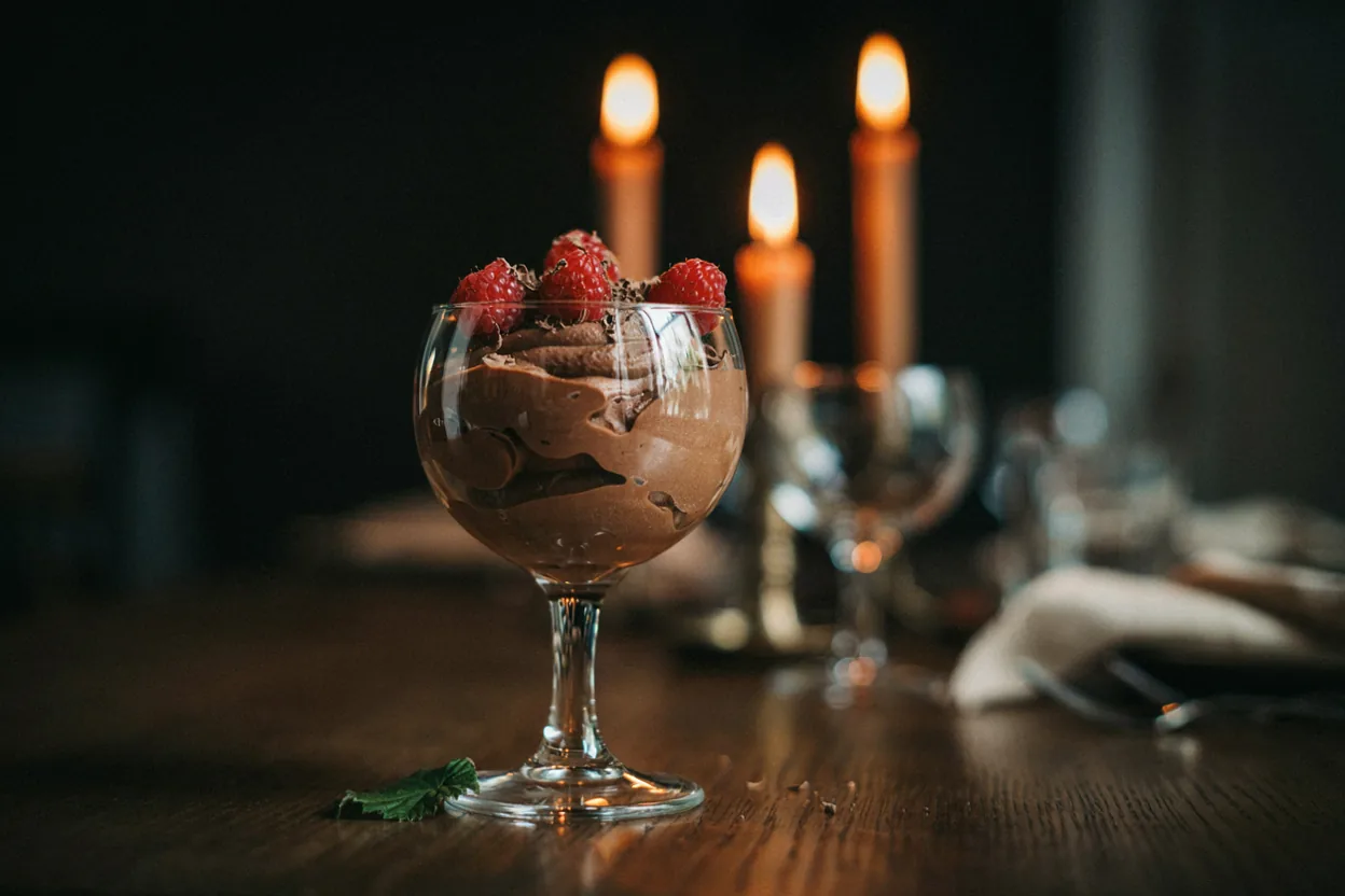 Čokoladni mousse u staklenoj čaši sa svežim malinama na vrhu