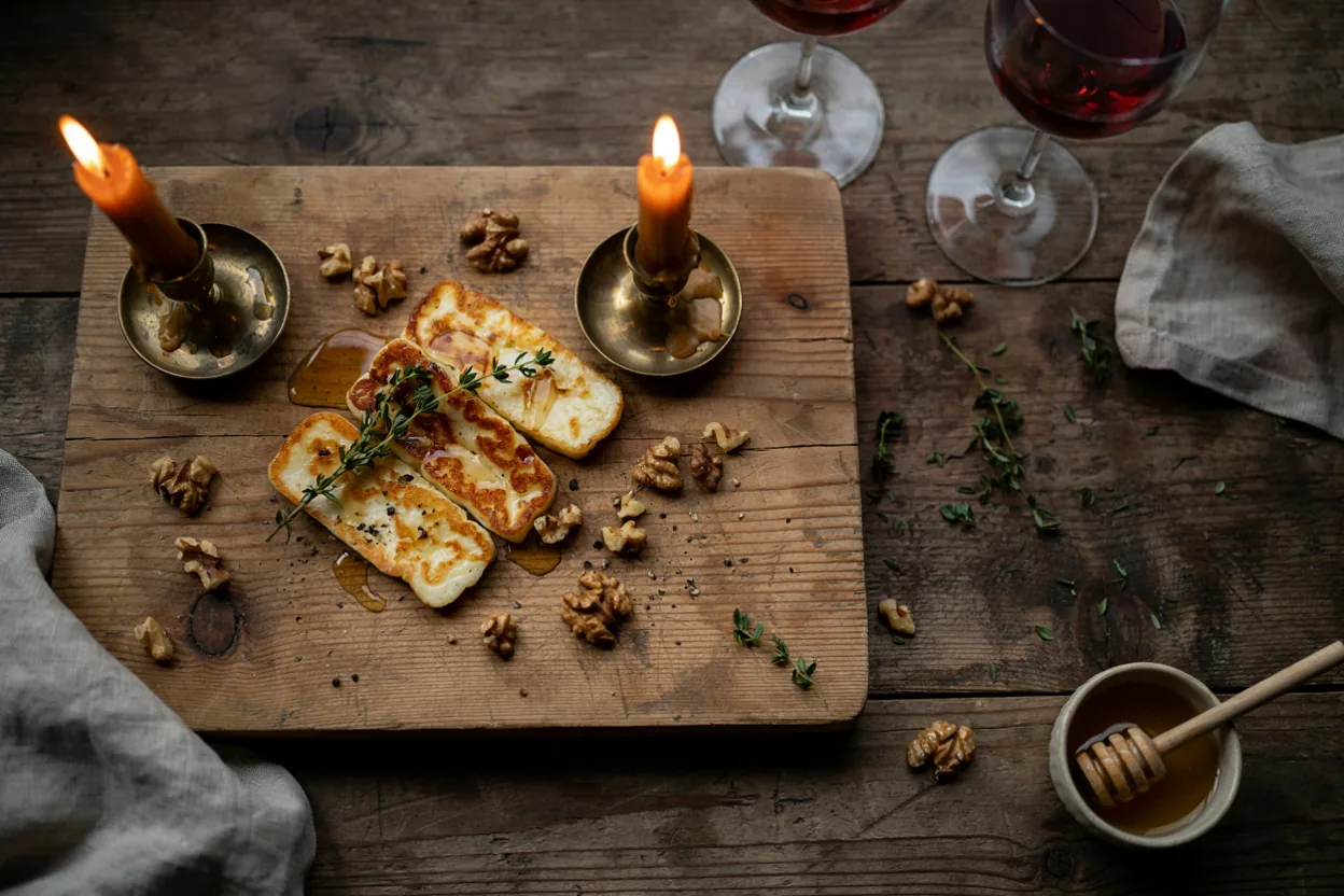 Pržene kriške halloumi sira sa medom i orasima na drvenoj dasci